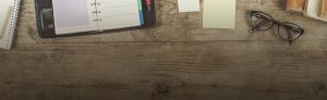 Desk with various items including a diary and glasses